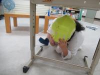 机の下に隠れる練習をします。